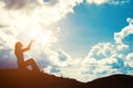 Silhouette of woman praying over beautiful sunrise