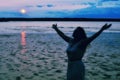 Silhouette of a Woman Raising Hands at Ocean