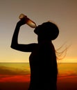 Silhouette of woman Rehydrate and refresh at sunset Royalty Free Stock Photo