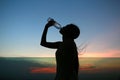 Silhouette of woman Rehydrate and refresh at sunset Royalty Free Stock Photo