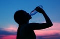 Silhouette of woman Rehydrate and refresh at sunset