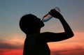 Silhouette of woman Rehydrate and refresh at sunset Royalty Free Stock Photo