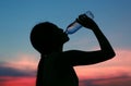 Silhouette of woman Rehydrate and refresh at sunset Royalty Free Stock Photo