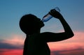 Silhouette of woman Rehydrate and refresh at sunset