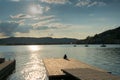 Silhouette of a woman relaxing on a floating dock on a lake at sunset Royalty Free Stock Photo