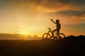 Silhouette of woman riding bicycle at sunset, cheerfully at the end of the day. Woman riding break relax and take a photo Royalty Free Stock Photo
