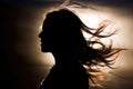 Silhouette of woman\'s head with waving hair, back light