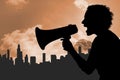 Silhouette woman screaming in megaphone against buildings and sky