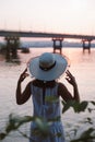 The silhouette of a woman by the sea at sunset. Rear view of the silhouette of a young woman in a straw hat enjoying the Royalty Free Stock Photo