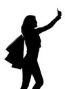 Silhouette of a woman with shopping bags doing selfie Royalty Free Stock Photo