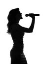 Silhouette of a woman singing with a microphone in hands Royalty Free Stock Photo