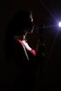 Silhouette of woman singing.