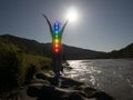 Silhouette of woman sits in a Upward Salute pose on beach sunset view, glowing seven all chakra. Kundalini energy. girl practicing