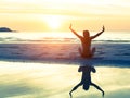 Silhouette of the woman sitting on the beach during amazing sunset, with reflection in the water. Royalty Free Stock Photo