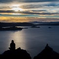 Silhouette of a woman sitting and enjoying the sunset near the lake Royalty Free Stock Photo