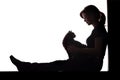 Silhouette of a woman sitting on the floor on a white isolated background with a cat in her arms Royalty Free Stock Photo