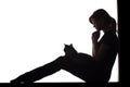 Silhouette of a woman sitting on the floor in a corner on a white isolated background with a cat Royalty Free Stock Photo