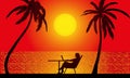 Silhouette of a woman sitting with a laptop at a table and palm trees against the backdrop of the setting sun over the sea Royalty Free Stock Photo