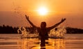 Woman splashing water in infinity pool at sunset Royalty Free Stock Photo