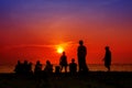 silhouette woman standing with family looking sunset on beach