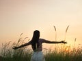 Silhouette of woman standing and open arm at sunset Royalty Free Stock Photo