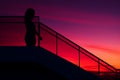 silhouette of a woman standing on the stairs at sunset Royalty Free Stock Photo