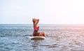 Sea woman sup. Silhouette of happy young woman in pink bikini, surfing on SUP board, confident paddling through water Royalty Free Stock Photo
