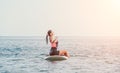 Sea woman sup. Silhouette of happy young woman in pink bikini, surfing on SUP board, confident paddling through water Royalty Free Stock Photo