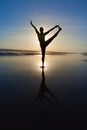 Silhouette of woman stretching at yoga pose on sunset beach Royalty Free Stock Photo