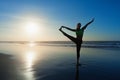 Silhouette of woman stretching at yoga pose on sunset beach Royalty Free Stock Photo