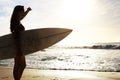 Silhouette, woman surfer on beach with sea and exercise outdoor with surfboard to surf in nature. Sport, shadow and sun Royalty Free Stock Photo