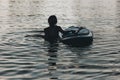 silhouette of woman swimming in water with sup board