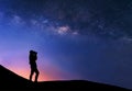 Silhouette of woman is taking the milky way photo on top of mountain. Royalty Free Stock Photo