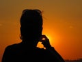 Silhouette of a woman taking photo at sunset Royalty Free Stock Photo