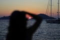 silhouette of woman taking pictures at sunset. (Selective focus) Royalty Free Stock Photo