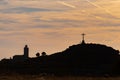 Silhouette of a woman on the top of a mountain at the foot of a cross