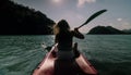 Silhouette of woman tourist raising hands while sailing in canoe along sea bay water to distant hilly island backside Royalty Free Stock Photo