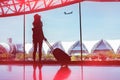 Silhouette woman travel with luggage looking without window at airport Royalty Free Stock Photo