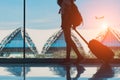 Silhouette woman travel with luggage walking side window at airport terminal international Royalty Free Stock Photo