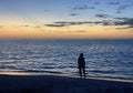 Silhouette of woman wading on a Florida beach after sunset.