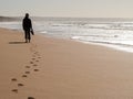 Silhouette of a woman walking alone at the beach Royalty Free Stock Photo