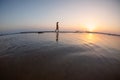 silhouette of a woman walking along the seashore. Spiritual Peace Meditation. A happy girl walks along the seashore against the Royalty Free Stock Photo