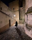 Silhouette of a woman walking at night on a narrow cobbled street in Lisbon, Royalty Free Stock Photo