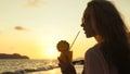 Silhouette woman walks on sunset on beach against background of Royalty Free Stock Photo