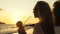 Silhouette woman walks on sunset on beach against background of Royalty Free Stock Photo