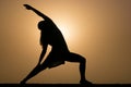 Silhouette of woman in warrior three yoga pose