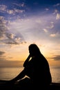 Silhouette of a woman watching colorful sunrise over the ocean Royalty Free Stock Photo