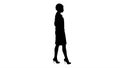 Silhouette Woman in white robe putting hard hat on while walking. Royalty Free Stock Photo
