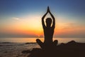 Silhouette of woman yoga in Lotus position on the shore of ocean. Royalty Free Stock Photo