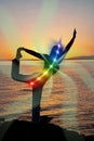 Silhouette of woman in yoga pose on beach sunset view, glowing seven all chakra. Kundalini energy. girl practicing meditation Royalty Free Stock Photo